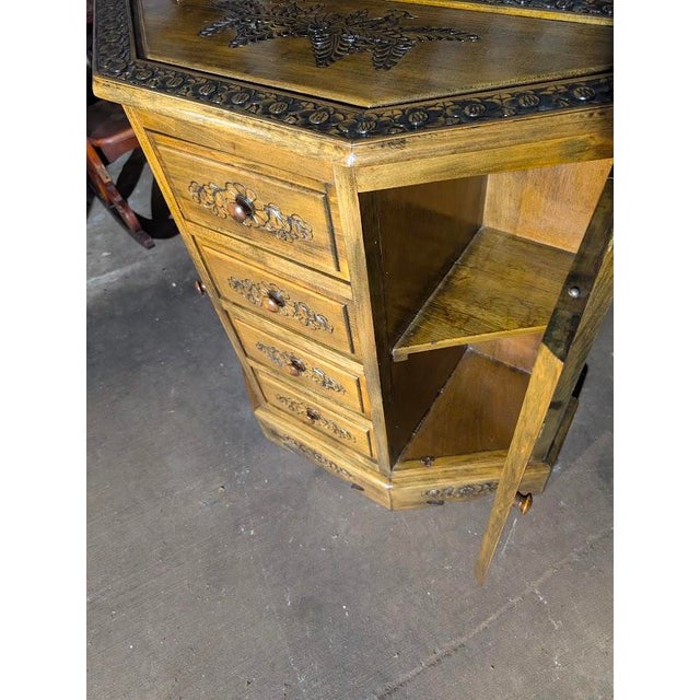 This stunning corner cabinet is a show-stopping piece of hand-crafted furniture featuring intricate, deep-relief carvings...