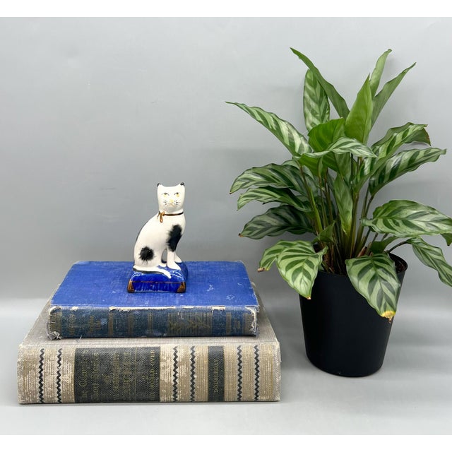 Charming black and white ceramic cat figurine, hand painted in the style of antique Staffordshire pottery. Features...