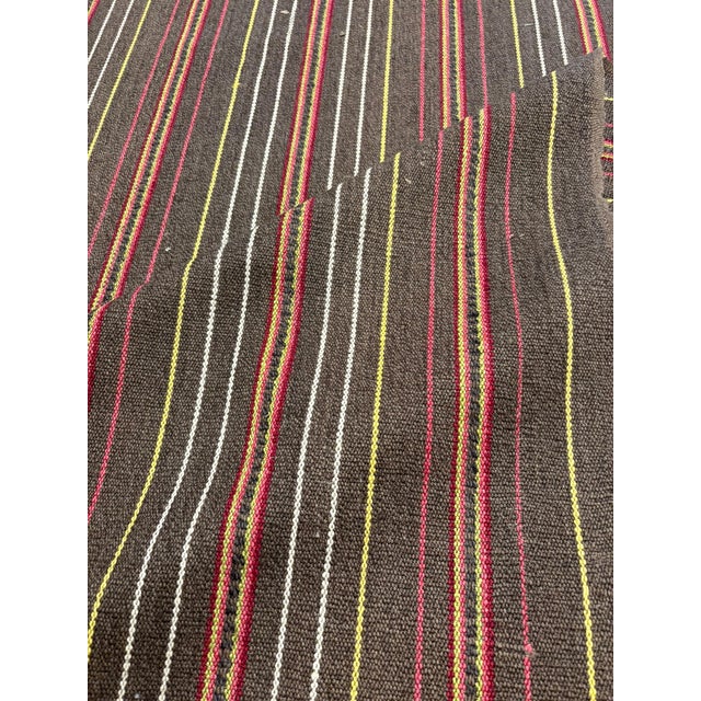 Osborne & Little's "Tabriz Bukhara" woven stripe fabric in pinks and greens on a chocolate ground is 54" wide and is a...