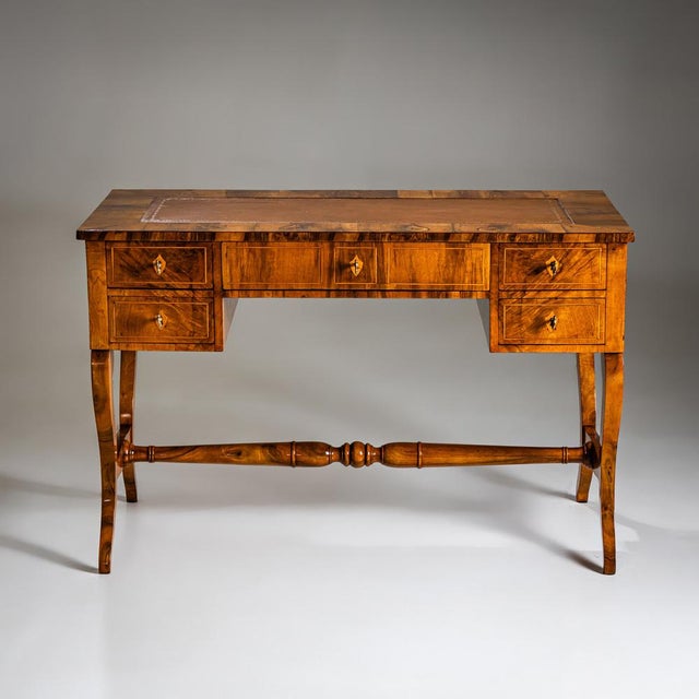 Biedermeier writing desk in walnut, crafted around 1830. Featuring five drawers framed with fine thread inlays and adorned...