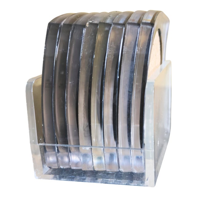 Set of 8 clear Lucite coasters with cork inserts in a matching Lucite caddy. Clean, minimalist design with Mid-Century...