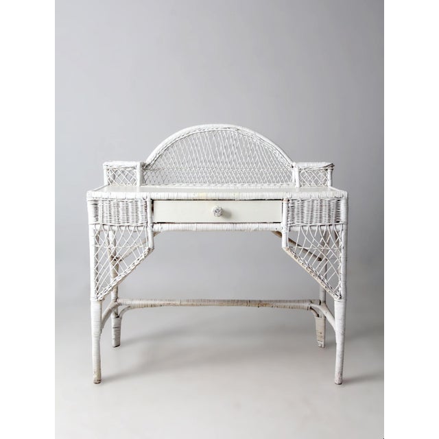 A vintage American wicker desk with an airy, relaxed presence and classic early 20th-century proportions. The woven frame...