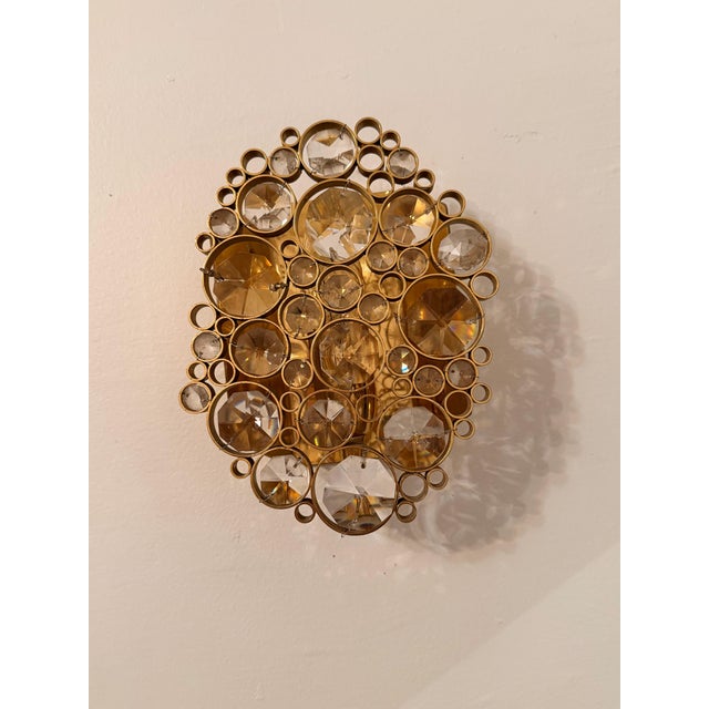A beautiful 1960s German Mid Century crystal and golden brass wall lamp by the maker, Palwa. One 60 w candelabra socket....