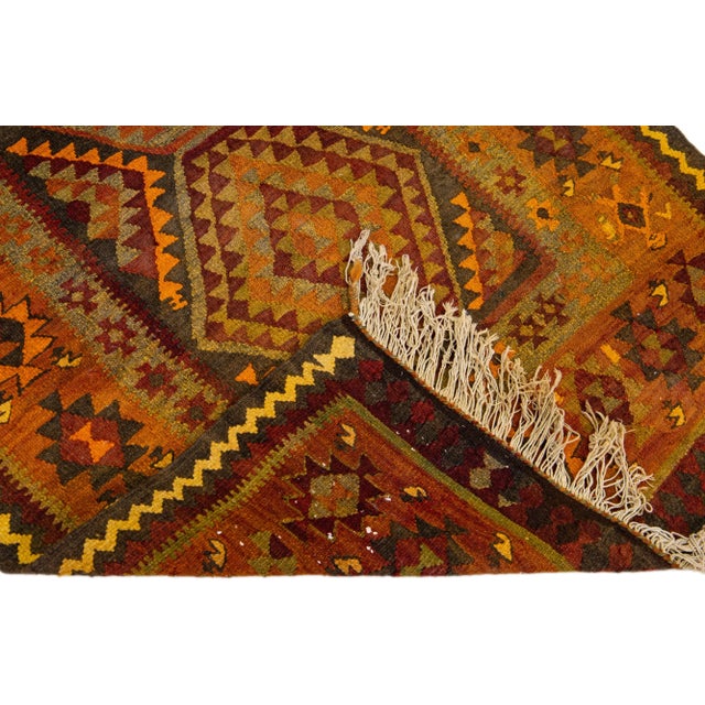Beautiful vintage Turkish Kilim hand-knotted wool rug with a red field. This piece has a rust frame and multicolor accents...
