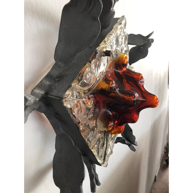 Vintage Italian wall light from the 1970s. The base is crafted from wrought iron and the shade is made of two-tone amber...
