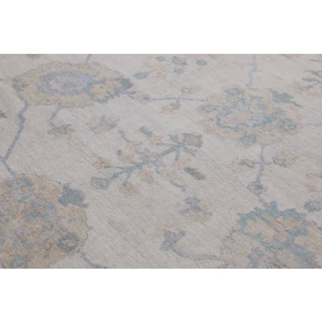 This modern Turkish Oushak rug is a stunning piece of art that has been handwoven using traditional techniques by skilled...