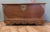 Carved Elm Coffer with Pierced Brass Decoration This large and heavy chest is set on wooden wheels and it has a carved...