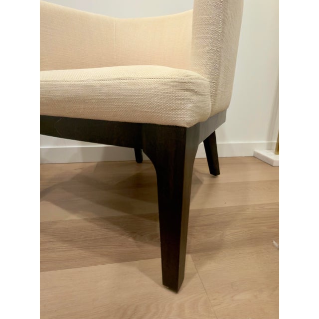 A pair of West Elm “Oliver” accent chairs featuring a soft modern silhouette with gently curved barrel backs and tapered...