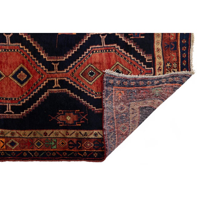 Elevate your interiors with this exceptional vintage hand-knotted Kurdish wool runner, featuring a rich, dramatic palette...