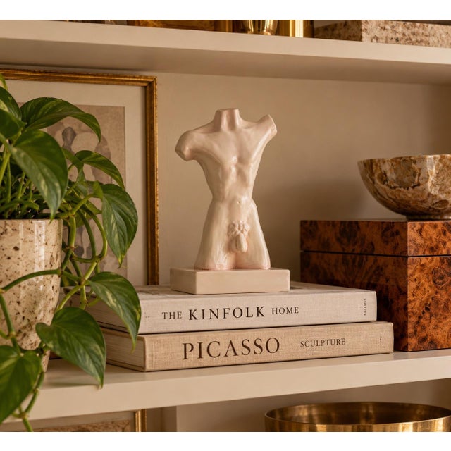 Striking 1980s ceramic sculpture depicting a stylized male nude torso, rendered in a soft ivory/blush glaze. The classical...