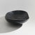 A black ebonized wooden bowl produced in the 1960s, distinguished by an organic form that appears to have been shaped...