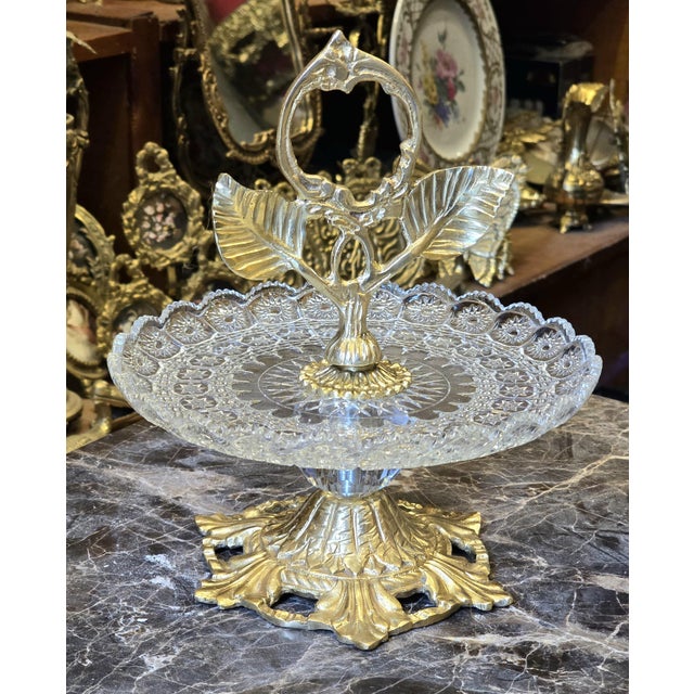 This luxury brass and crystal pedestal serving stand is designed to elevate elegant gatherings and refined table...