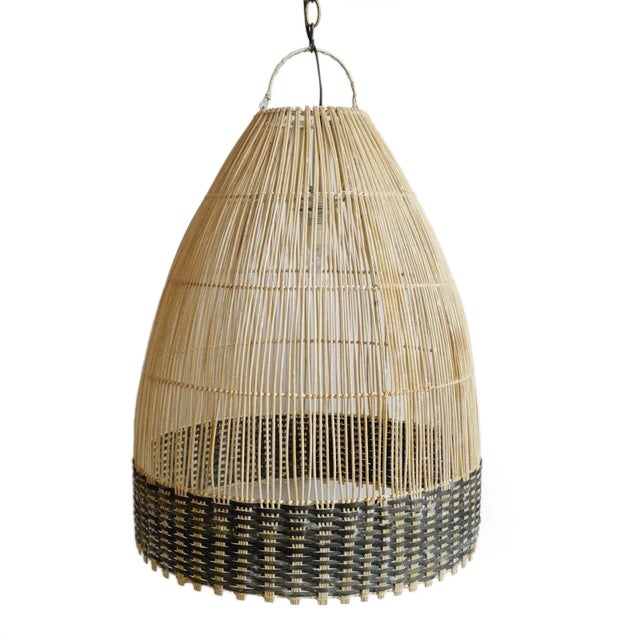Handsome raw wicker tux weave pendant lantern. Beautiful natural material with black stain wicker band around the edge...