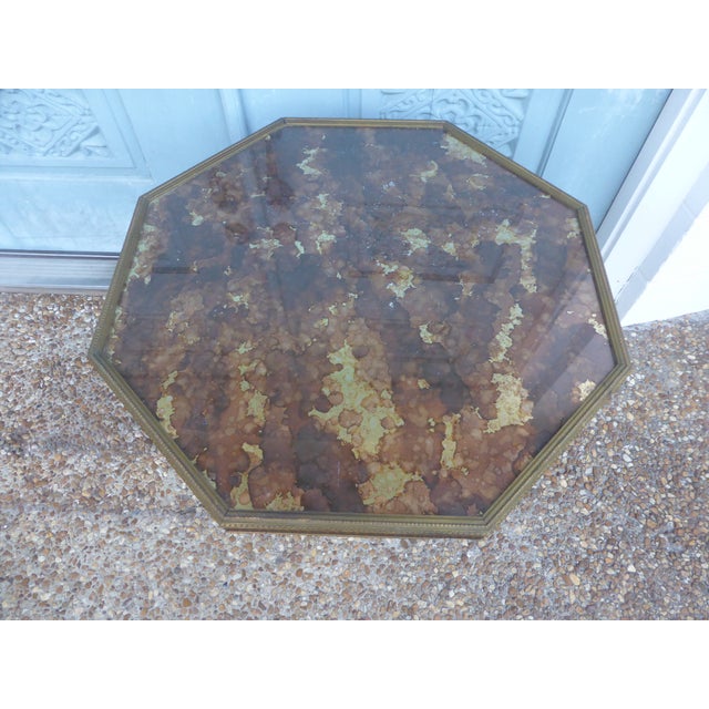 Octagon surface with glass top pedestal table. Under the glass, there is colored mosaic flow pattern. The pedestal is made...