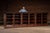 Expansive multi-bay library cabinet featuring a continuous run of glass-front display sections framed by richly carved...