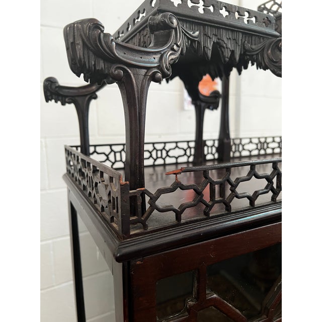 An exceptional 19th-century style mahogany display cabinet features a tripartite architectural façade. The central section...