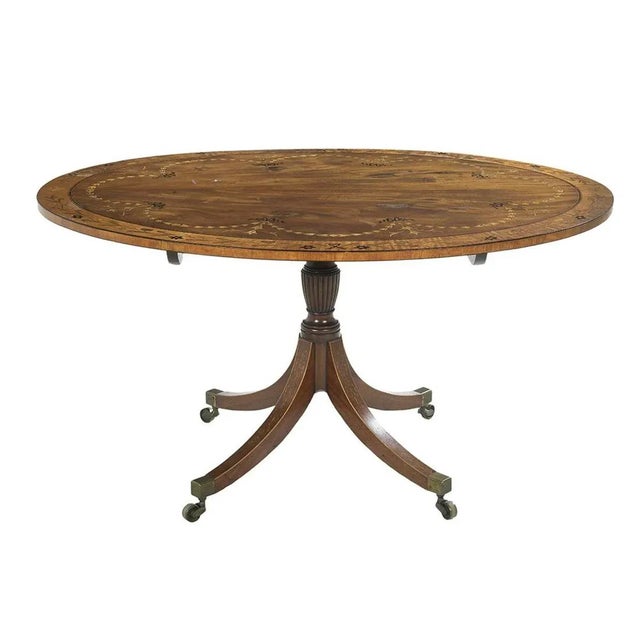 Impressive Neoclassical tilt top oval table in mahogany with impressive bow knot, bell flower swag festoon inlay and cross...