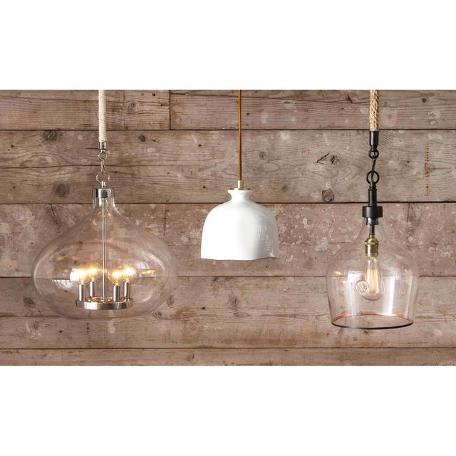 A subtly textured glass demi john bottle hangs from twisted jute rope to illuminate & add refreshing character over an...