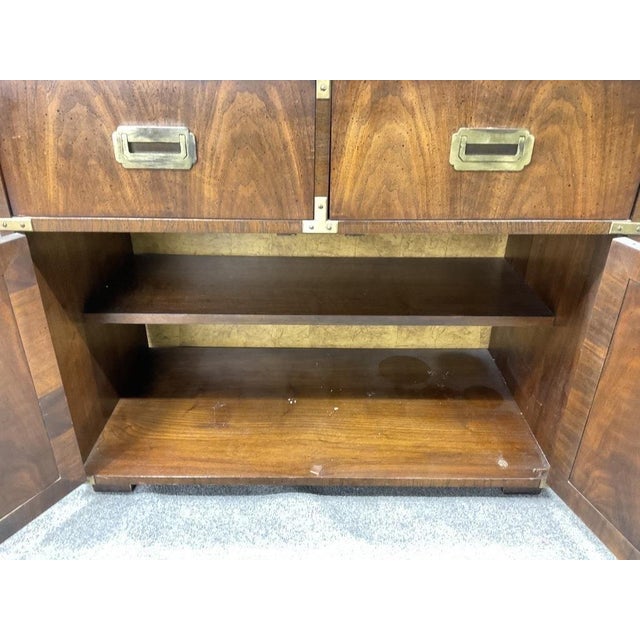 A beautifully crafted vintage Lane Campaign server cabinet featuring rich walnut veneers, fluted blind-door fronts, and...