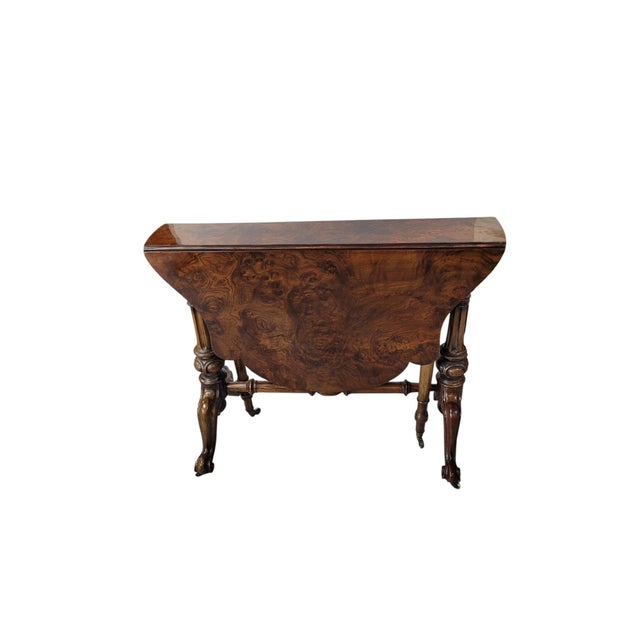 An exceptional English Victorian Sutherland drop-leaf table in richly figured burr walnut, circa 1860–1880. The tabletop...