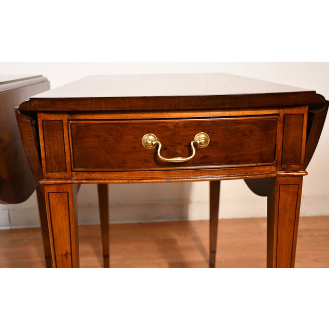 We are pleased to offer this beautiful pair of Pembroke drop-leaf side tables, from the 1950s . This pair is made of...