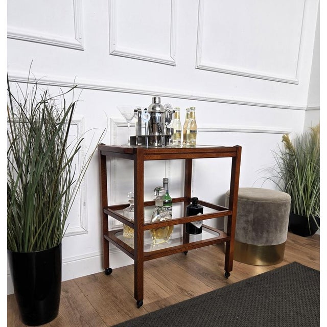 Unique and very elegant Italian Mid-Century Regency dry bar cabinet cart with two glass tiers and highlighted by the great...