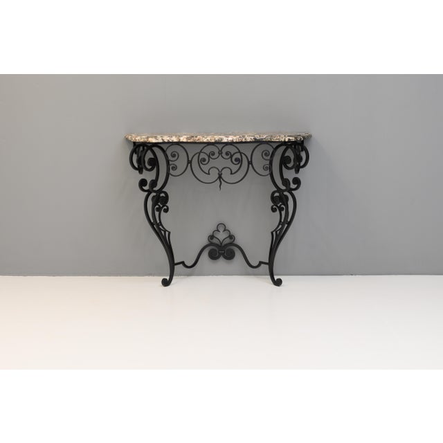Mid-century shaped marble top console on decorative wrought iron base (repainted). Circa 1950.