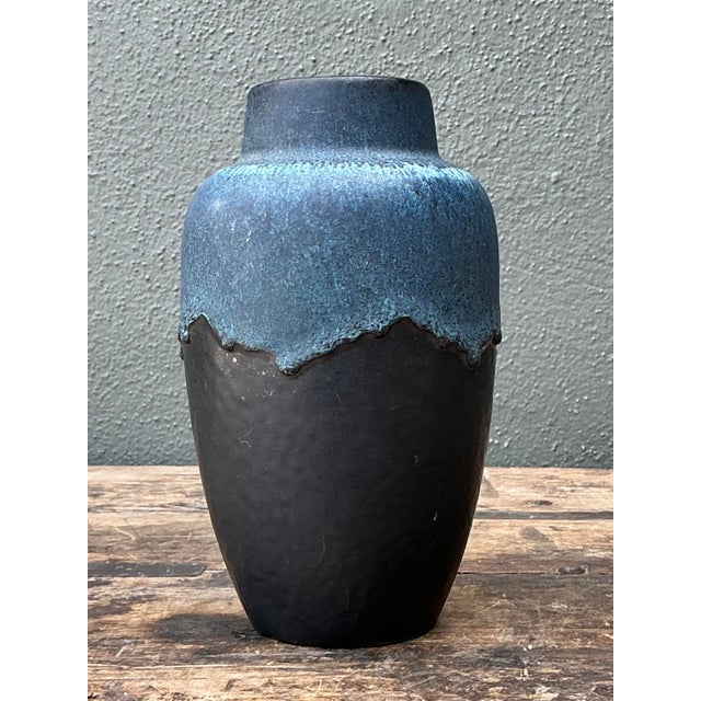 This captivating vintage studio pottery vase is a masterclass in textural contrast and organic form. The vessel features a...