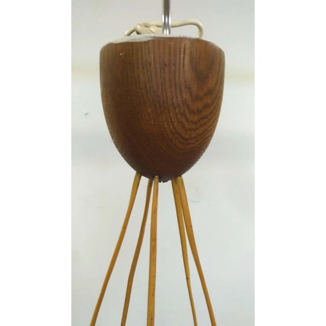 This chandelier was produced by Luxus in Sweden in the 60s. It has a wooden frame and white opal glass diffusers. It is...