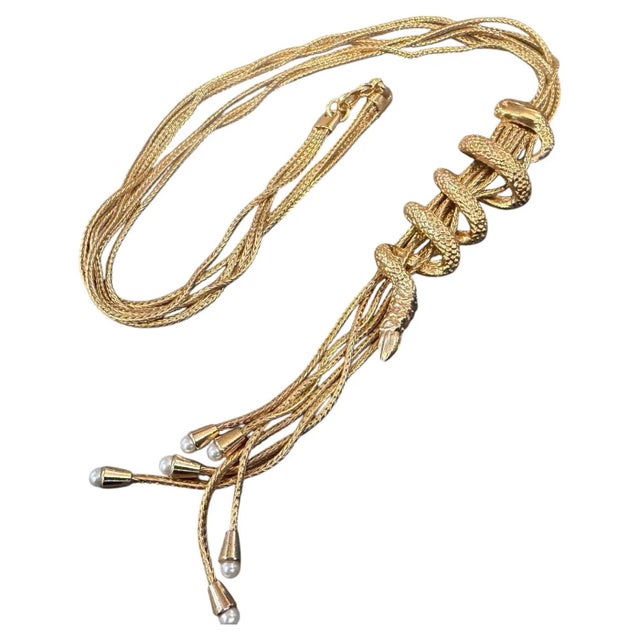 This striking 2000s costume jewelry piece features a lariat-style snake necklace crafted from gold-toned gilt metal. The...