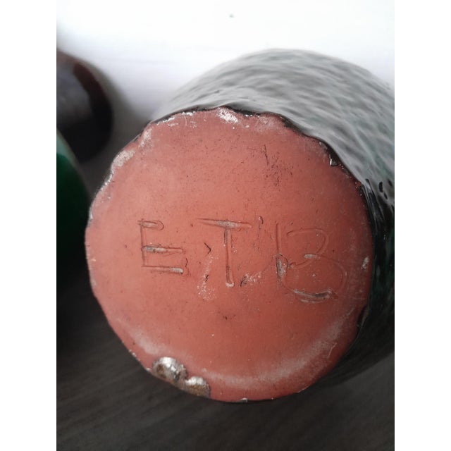 A collection of three ceramic vessels, likely jugs and a vase, featuring distinctive glazed finishes. The left and center...