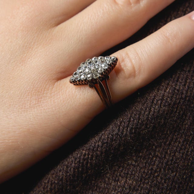 This enchanting Victorian ring showcases a beautiful arrangement of old mine cut diamonds, each stone reflecting the charm...