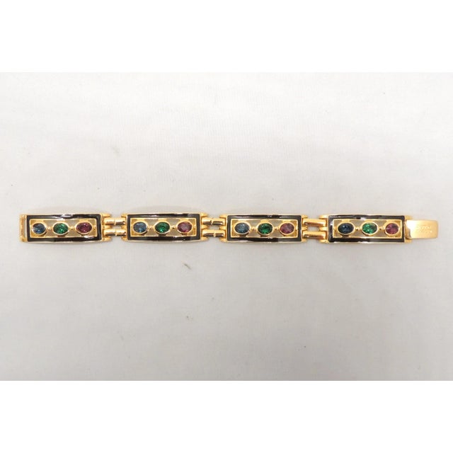 This is part of Chairish’s Costume Jewelry assortment. 1980s goldtone black enamel with oval faux-sapphire, faux-emerald...