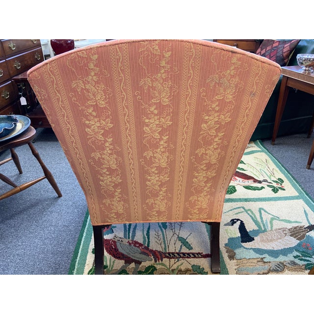 20th Century Georgian style wing back chair. Upholstered in a pink grape vine pattern fabric. Wood legs.