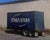 Trailer by Brad Davis | Oil on panel Painting of a blue shipping container on a trailer. For Sale