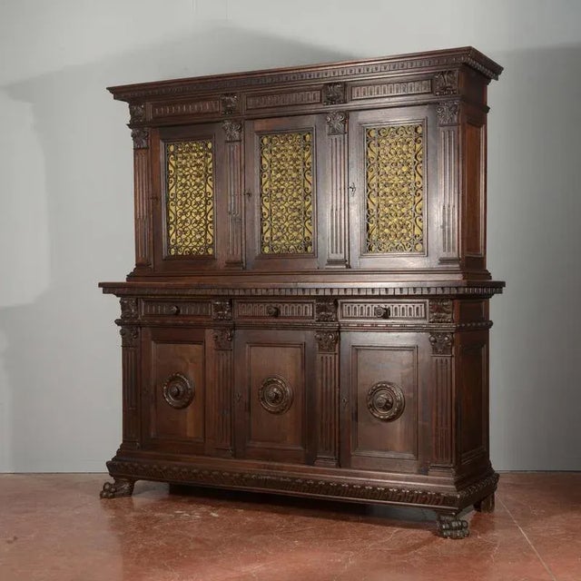 Carved bookcase sideboard with 3 closed doors, 3 drawers, and 3 doors on the upper part embellished with a wrought iron...