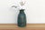 This painted wooden vase is a vibrant study in texture and color. This vintage hand-turned wooden vase features a tall,...