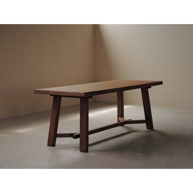 French artisanal table, crafted in the 1970s, it combines a solid oak structure with an oak-veneered top. The design is...