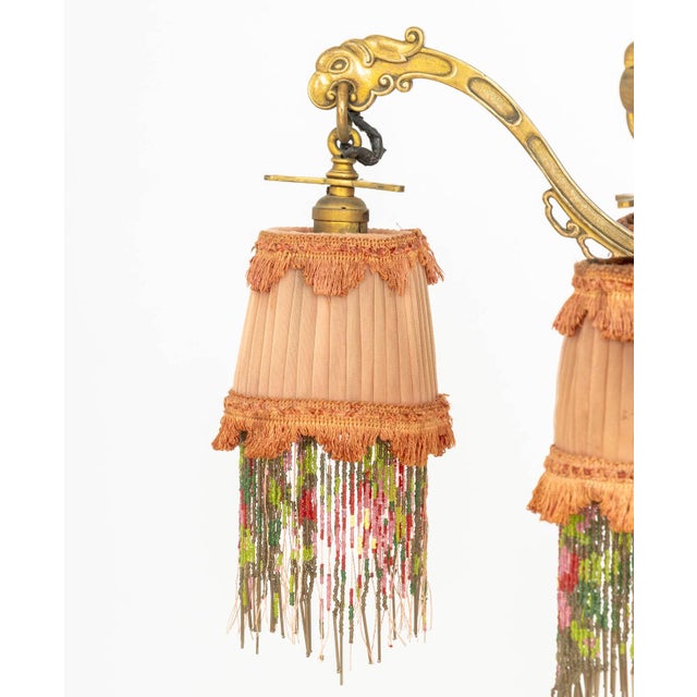 Art Deco Chinoiserie Style Six-Branch Chandelier, the gilt metal mythical beast motif arms stemming from a red tole peinte...