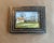 A serene landscape watercolor capturing a peaceful rural scene with modest homes, bare trees, and open grassy fields under...
