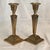 These candle holders feature ornate ram's head and ribbon motifs on tapered stems with square bases.