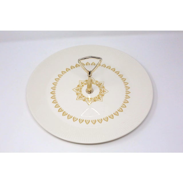 A vintage, 12 1/2" diameter beige serving platter, with a gold-colored stencil design and handle. Good condition; no chips...