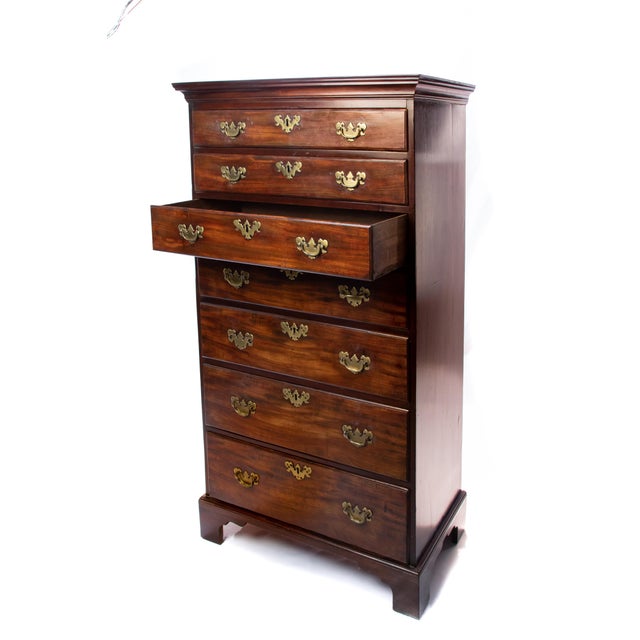Offering this stunning tall chest in mahogany. Starting at the bottom on a bracket leg it rises. The narrow tall chest has...