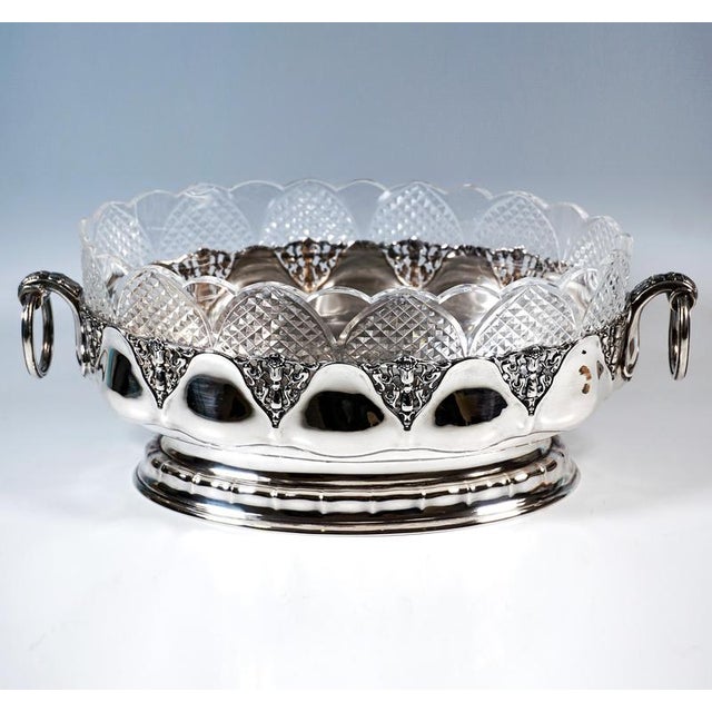 Elegant, festive silver vessel in an oval shape on a flush, curved stepped base with a gentle, bamboo-like ribbed...