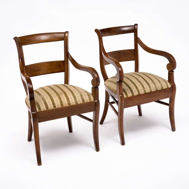 Elegant pair of early 19th century French Restoration period armchairs, circa 1820, crafted from solid walnut in the Rhône...
