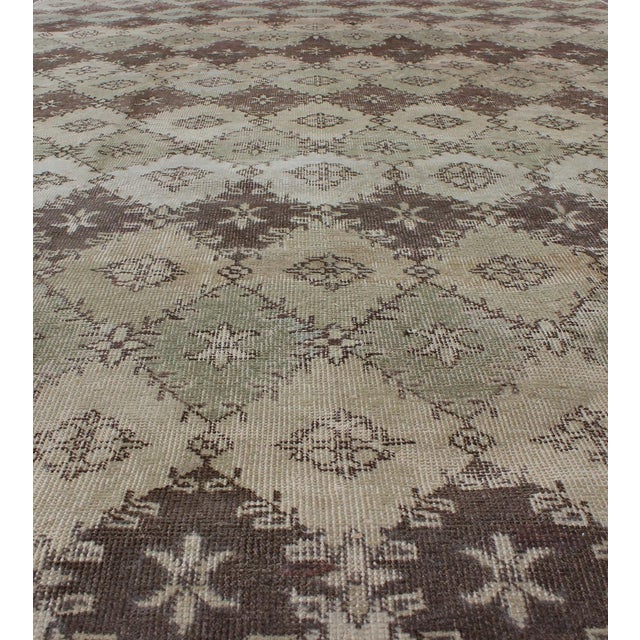 Measures: 6'8 x 12'. This vintage Turkish Mid-Century Modern distressed rug is rendered in diamond pattern and a speckled...