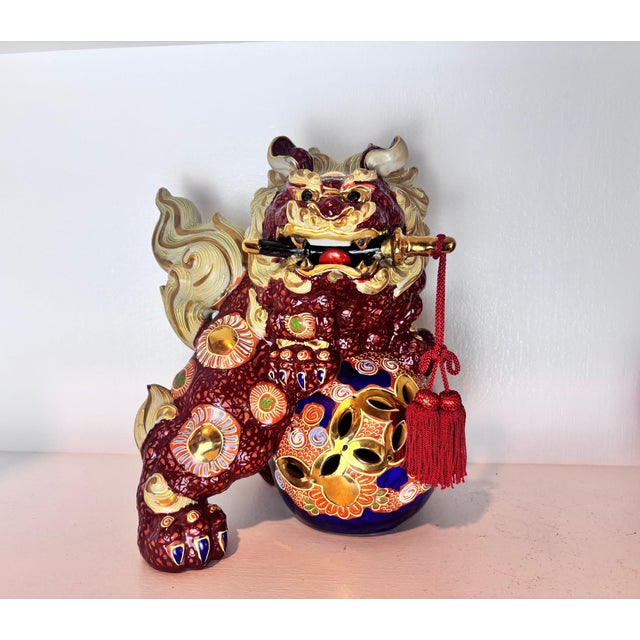 A striking pair of vintage Japanese Kutani-yaki guardian lion figurines, commonly known as Foo Dogs or Fu Lions, dating to...