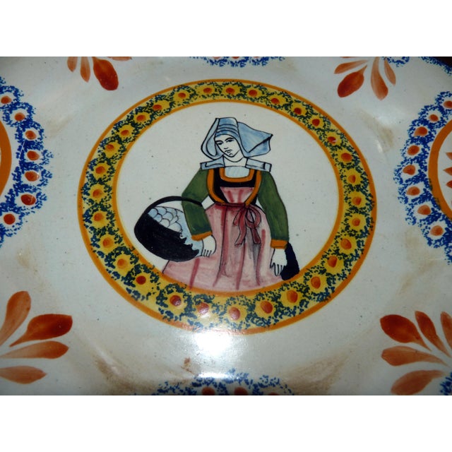A beautiful, hand-painted companion piece to the traditional Breton Piper, this authentic 1930s Henriot Quimper plate...