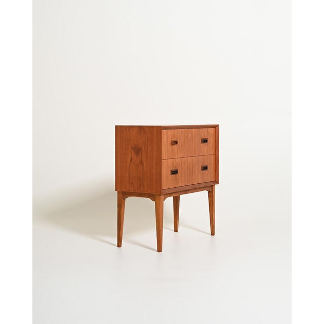 Teak frame with two drawers, solid wood recessed rectangular handles, dovetail joints, and tapered legs. Scandinavian...