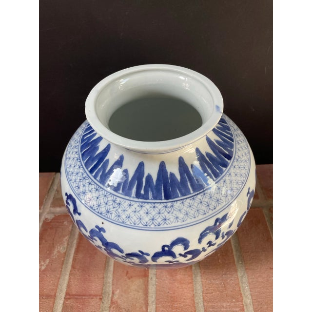 Vintage Chinese porcelain jar / vase features a hand painted repeating floral motif in vibrant royal blue on a white...